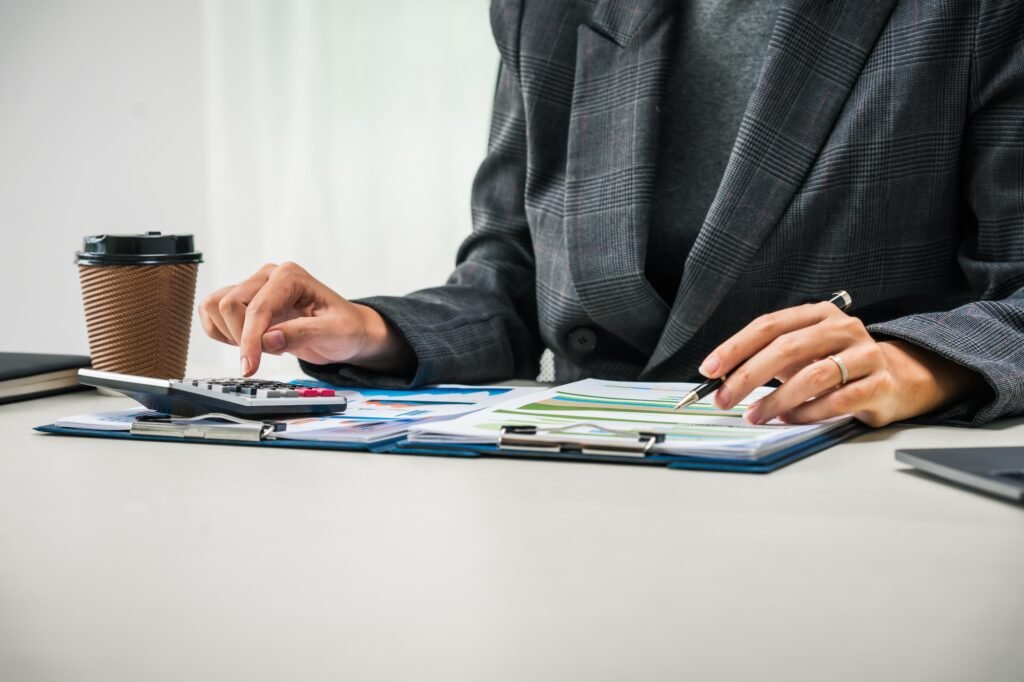 businesswoman works diligently at her desk, reviewing financial documents and analyzing investment